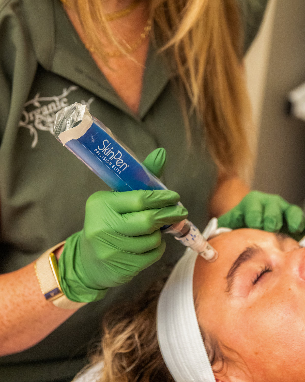 Close view of gloved hands holding a SkinPen Elite device during a microneedling treatment at Organic Skin and Body