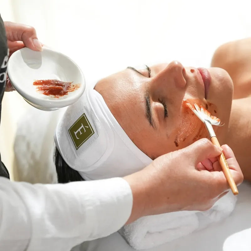 Esthetician applying an organic facial mask